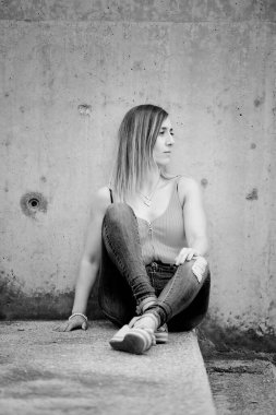 Merdivenlerde oturan İspanyol bir kadının dikey görüntüsü.