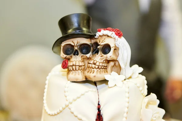 頭骨のトッパーと赤いバラの白い結婚式のケーキ 骨格の形で花嫁と新郎 — ストック写真