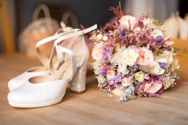 Düğün ayakkabıları ve yerde bir buket var.