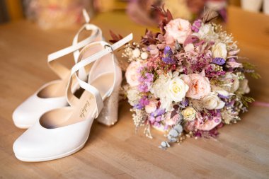 Düğün ayakkabıları ve yerde bir buket var.