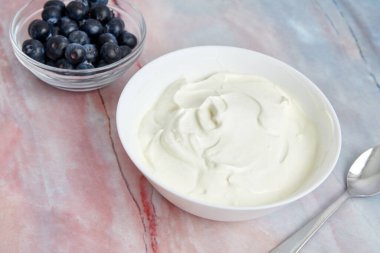 Yunan yoğurdu ve mermer bir arka planda yaban mersinli kase