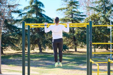 Parkta egzersiz yapan genç çocuk.