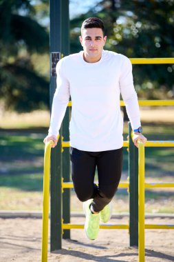 Parkta egzersiz yapan genç çocuk.