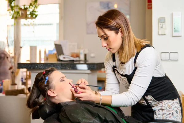 Kuaför Makyaj Yapıyor Bir Güzellik Salonunda Genç Bir Bayan Müşteriyi — Stok fotoğraf