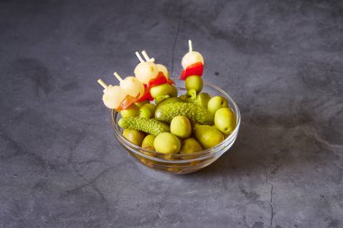 Siyah arkaplanda İspanyol esmerleri olan cam bir kase.