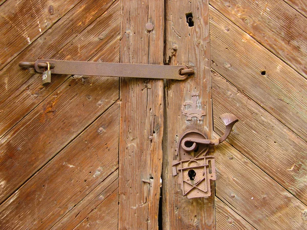 Old wooden door with rusty iron hinges and handle — Stock Photo, Image