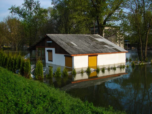 Überflutetes Haus an einem Flussufer Stockbild