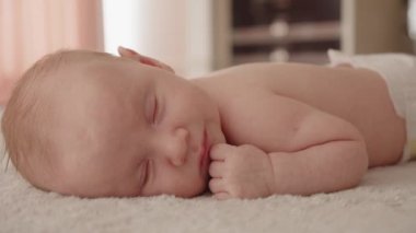 Evde uyuyan bir bebek. Güzel küçük bebek uyumak üzere. Bebek uykusuna yakın çekim. Kafkasyalı küçük bir bebeğin dinlenme görüntüsü. Şekerleme çocuğu, öğle uykusu..