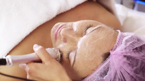 在温泉沙龙里做美容护理的妇女 美容师使用医疗设备制定医疗程序 美容师使妇女成为脸上的一种治疗方法 — 图库视频影像
