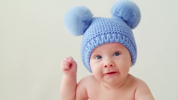 Щаслива Новонароджена Дитина Блакитному Капелюсі Помпонами Дивиться Камеру Усміхнений Двомісячний — стокове відео