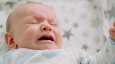 Bebek ağlamasının yakın plan yüzü. Beyaz bebek bağırıyor. Çocuk ağlıyor. Kötü bir ruh halinde küçük bir bebeğin yavaş çekim videosu.