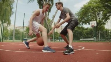 Sıcak bir yaz gününde sokak basketbolu oynayan insanlar. Güneşli bir yaz gününde açık hava sahasında basketbol oynayan iki genç. Saldırı ve savunma, atış yok..