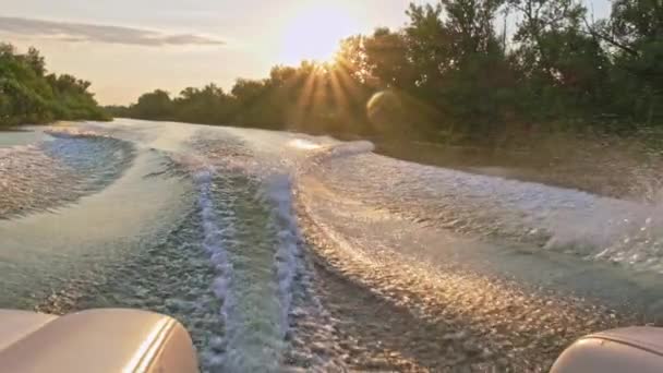 慢动作夹子 快艇产生美丽的波浪 从高速运动的马达上喷出 在夏日美丽的落日下 从船尾眺望风景 引擎搅动水 — 图库视频影像