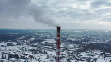 Duman dumanı karbon ve kirlilik emisyonları endüstri bacalarından geliyor. Sinematik görüntüler. TPS istasyonunun endüstriyel bir girişimi tarafından atmosfer kirliliği. Kışın bulutlu bir gün.