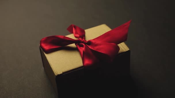 Caja Regalo Con Cinta Roja Sobre Fondo Negro — Vídeo de stock