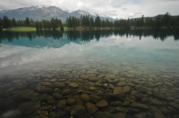 Чисте озеро та сніговий гірський масив — стокове фото
