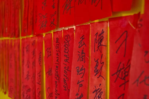 Handgeschreven chinese kalligrafische karakters op rode tags — Stockfoto