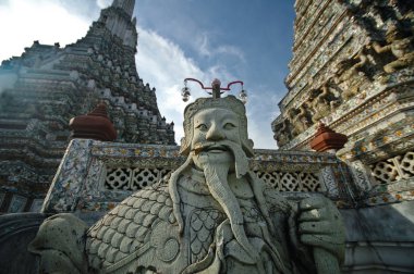 Old Chinese giant statue with Bangkok temple of dawn and blue sky clipart