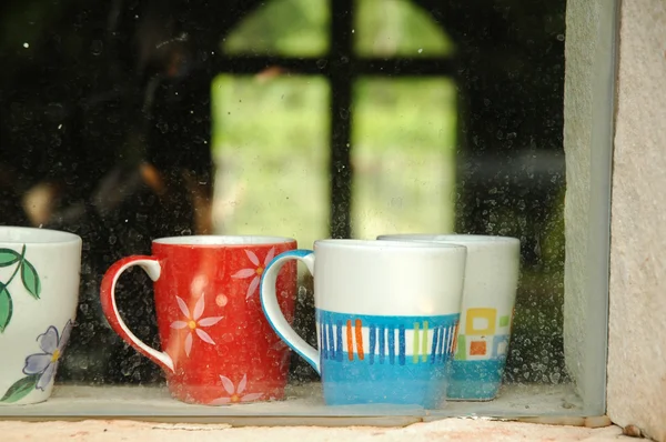 Warm coffee cups inside a window of a cozy house — Stock Photo, Image