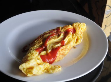 Tüylü, lezzetli, sarı, beyaz tabakta omlet.