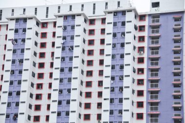 Mor beyaz gökdelenli düz beyaz daireler bazı pencereler açık ve giysiler dışarı sarkmış