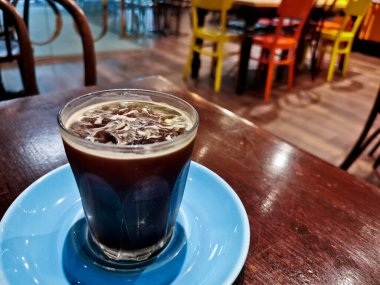 Cold brew iced fresh Americano coffee served in a glass on wooden table