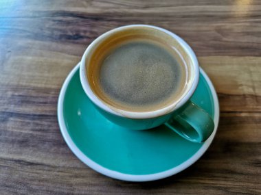 Hot plain black Americano coffee served in glass mug on wooden table