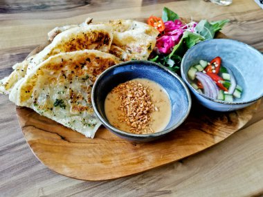 Sarımsak naan roti hafif ızgara düz ekmek ve fıstık satay sosu ve bahçe salatası ve salatalık sirkesi