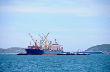 Güneşli bir günde kargoları okyanusta yüzdürmek için vinçleri olan büyük lojistik nakliye gemisi.