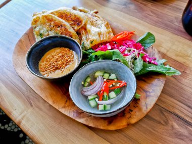 Sarımsak naan roti hafif ızgara düz ekmek ve fıstık satay sosu ve bahçe salatası ve salatalık sirkesi