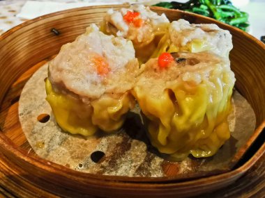 Siu Mai steamed prok prawn mushroom Chinese dumplings in bamboo basket in Yum Cha restaurant