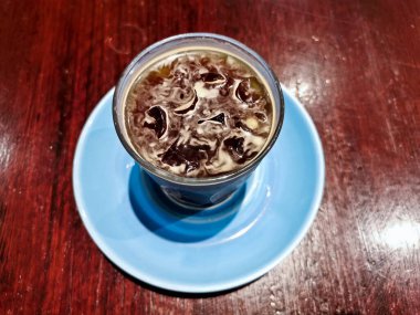 Cold brew iced fresh Americano coffee served in a glass on wooden table