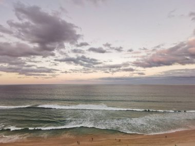 Calm serene tranquil twilight evening scene of Surfer Paradise beach in Gold Coast Australia from bird eye view. There are many people on the beach.