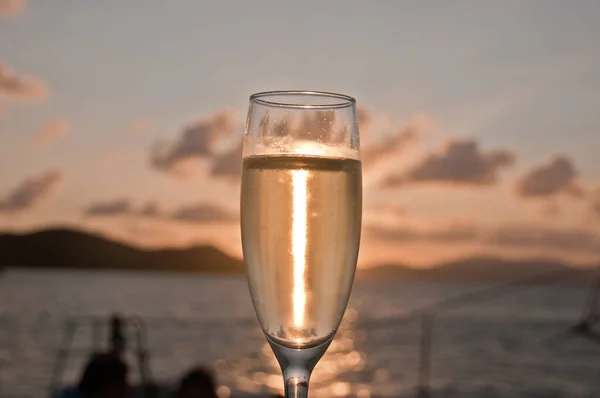 Bubby sparkling champagne flute glass with Sunset evening scene while sailing in the Pacific Ocean in Queensland Australia