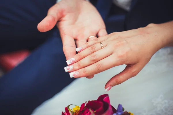 Hand van de bruidegom en de bruid met bruiloft ringen — Stockfoto