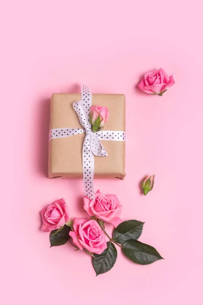 Artesanato caixa de presente sobre fundo rosa com rosas cor de rosa. Dia dos Namorados. Dia das Mães. — Fotografia de Stock