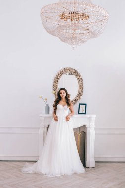 Gelinlikli göz kamaştırıcı gelin stüdyoda duruyor. Gelin stili
