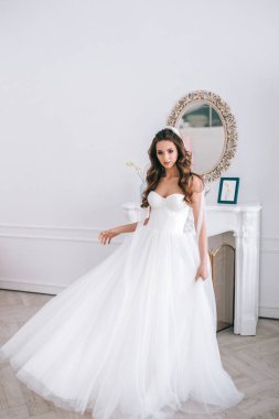 Gelinlikli göz kamaştırıcı gelin stüdyoda duruyor.