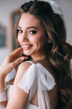 Stüdyoda lüks makyaj ve saç stili olan mutlu gelinin güzel yakın plan portresi. Gelin stili