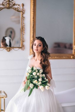 Gelinlikli güzel gelin stüdyoda oturuyor.