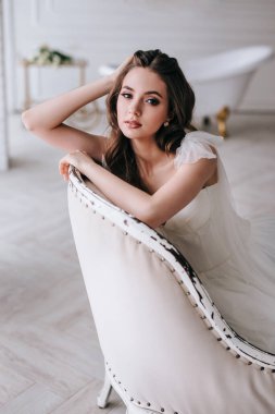 Gelinlikli güzel romantik gelin stüdyoda oturuyor.