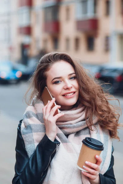 Junge Frau unterhält sich mit Kaffee auf Handy — Stockfoto