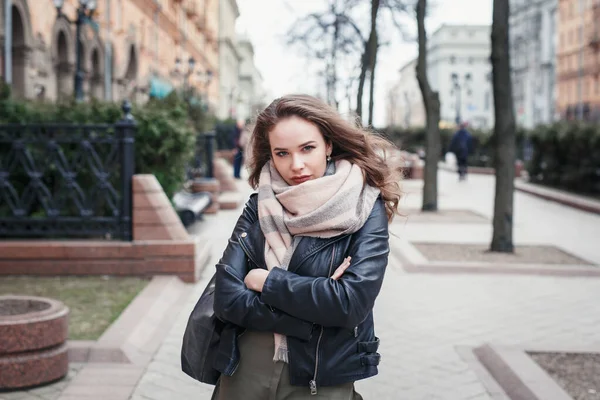 Jonge vrouw in zwart lederen jas lopen op straat — Stockfoto