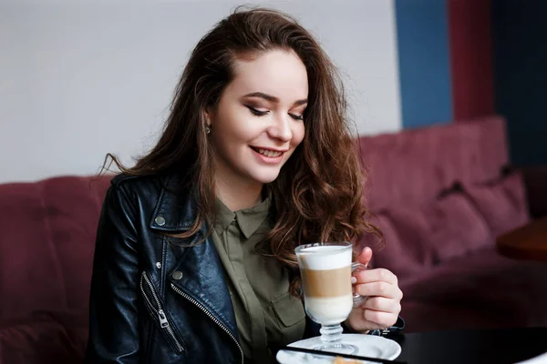 Kafede kahve içen, aşağıya bakan mutlu genç bir kadın. - Stok İmaj