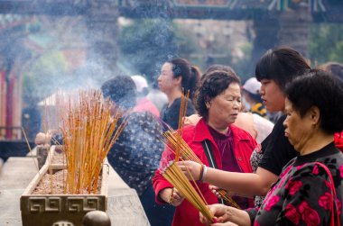 Hong kong - 27 Mart 2014: ziyaretçi yanık tütsü sopa ve ana sunak sik sik yuen wong tai sin temple hong Kong'da bulunan dua ediyor. Eskiden, wong tai sin ünlü keşiş anısına.