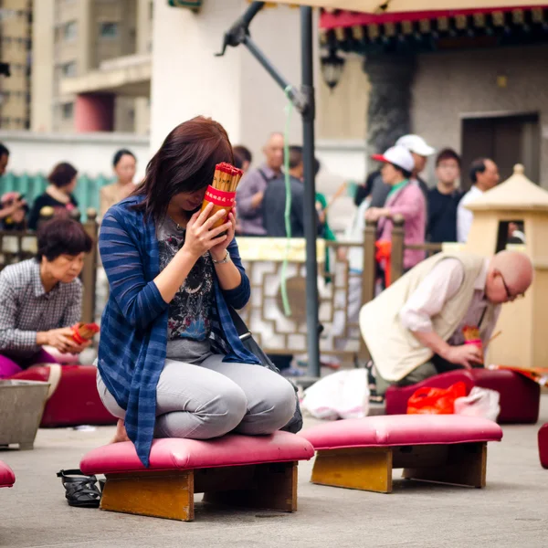 ГОНКОНГ - 27 МАРТА 2014: Бросание жосс палочки и молиться за удачу и удачу среди благовоний в храме Вонг Тай Син в Гонконге  . — стоковое фото