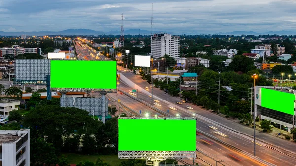 Bovenaanzicht van highway bij nacht met groen scherm billboard — Stockfoto