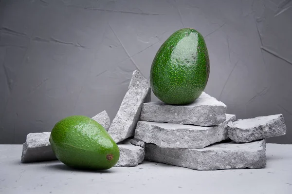 Avokado gri bir taş masada. Meyve sağlıklı gıda konsepti. 
