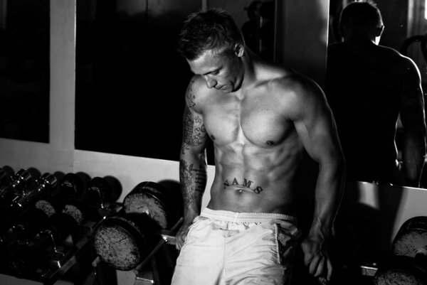 Сильный мужчина отдыхает после тренировки
