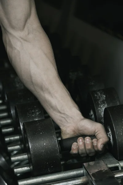 Strong mans arm reaching for dumbbell — Stock Photo, Image